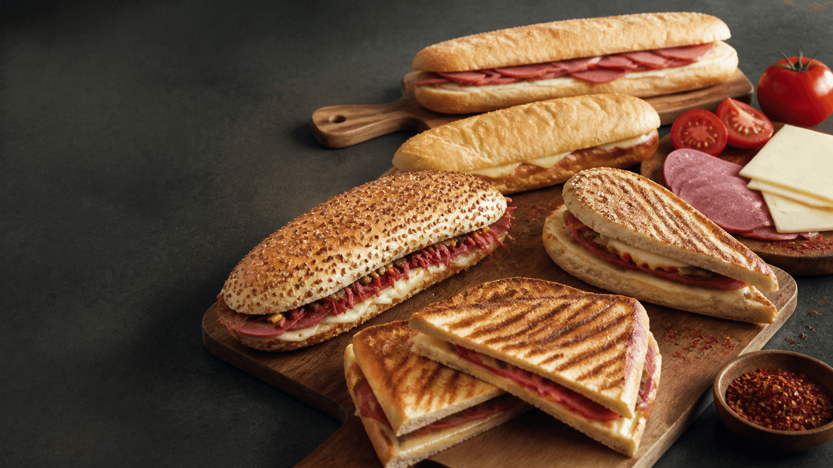 Tost ve sandviç çeşitlerinin ahşap servis üzerinde ürün kolajı